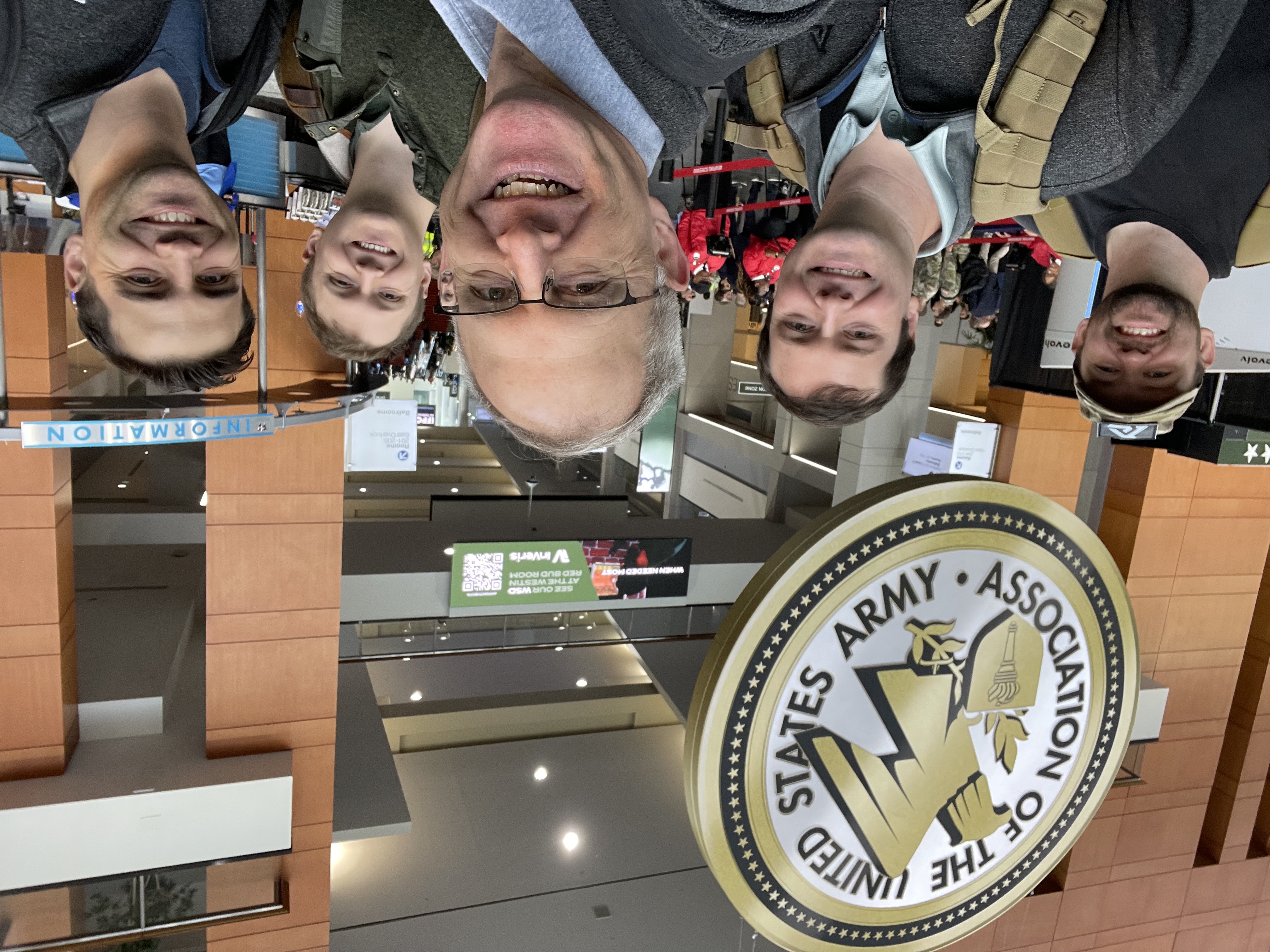 Rob with teammates at AUSA, beneath the Association of the United States Army seal